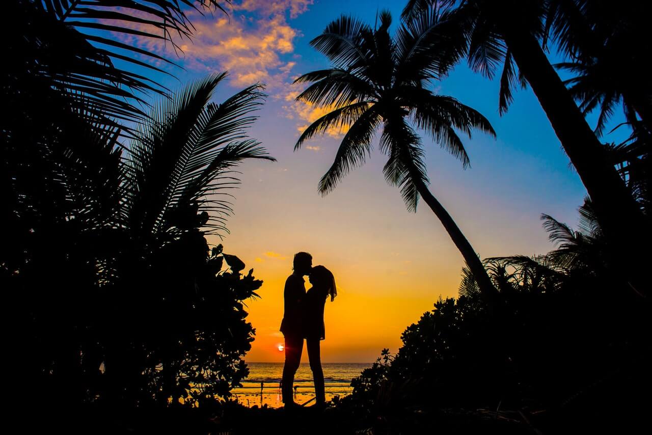 Image d'un couple s'embrassant au coucher du soleil