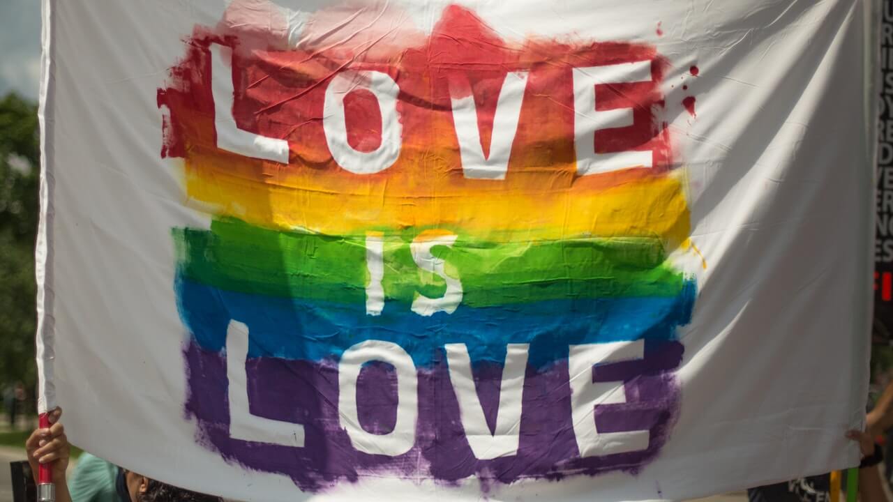 Image d'un drapeau LGBT disant "Love is Love" (l'amour est l'amour)