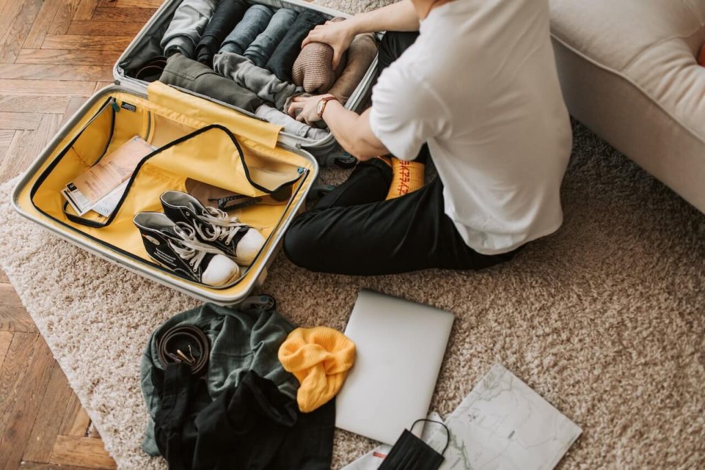 Image d'une personne faisant habilement sa valise, en pliant et en arrangeant efficacement chaque article.